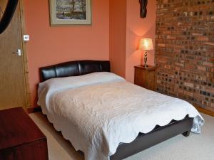 a bedroom with a bed and a brick wall at The Water Tower in Auchmithie