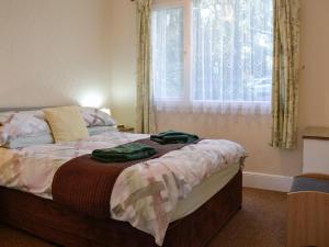 イフラクームにあるMagnolia Cottageのベッドルーム1室(ベッド1台、緑のタオル2枚付)
