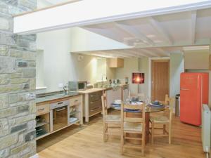 a kitchen with a table and a red refrigerator at The Bothy House in Berwick Hill