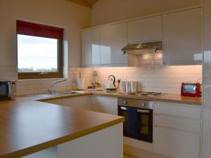 a kitchen with white cabinets and a sink at Bramble in Orby