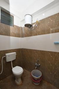 a bathroom with a toilet and a light on the wall at VIJAY BALAJI MAHAL A/C in Tiruvannāmalai