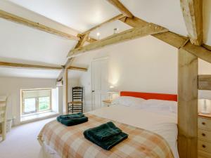um quarto com uma cama num quarto com vigas de madeira em The Wheel House em Potto