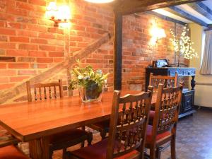 une table en bois avec un vase de fleurs. dans l'établissement Tudor Cottage, à Romsey