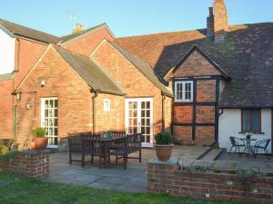 Casa de ladrillo con patio con mesa y sillas en Tudor Cottage en Romsey