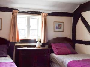 sypialnia z 2 łóżkami i oknem w obiekcie Tudor Cottage w mieście Romsey