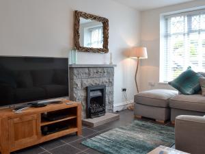 a living room with a television and a fireplace at Wendon in Criccieth