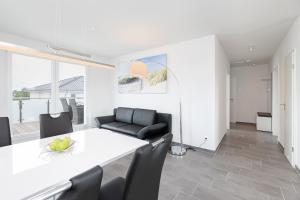 a dining room with a white table and black chairs at Brenkenhagener Weg 4 Wohnung 7 in Grömitz