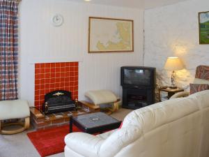 sala de estar con sofá y TV en Achd en Nedd