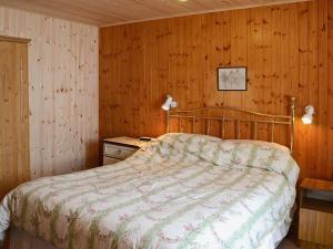 1 dormitorio con 1 cama y pared de madera en Achd en Nedd