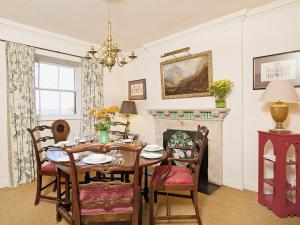a dining room with a table and a fireplace at Gardeners Cottage-uxt in Corsock