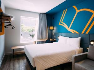 um quarto de hotel com uma cama e uma janela em ibis Styles Poços de Caldas em Poços de Caldas
