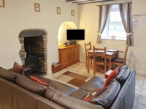 a living room with a couch and a fireplace at 4 Tan Y Bryn Terrace in Prenteg