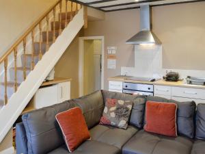 a living room with a couch and a kitchen at 4 Tan Y Bryn Terrace in Prenteg