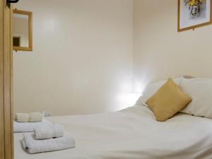 a bedroom with a white bed with towels on it at 4 Tan Y Bryn Terrace in Prenteg