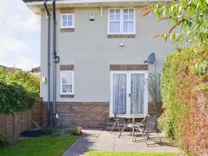 a house with a table and chairs in front of it at Beach Walk Cottage in Scarborough