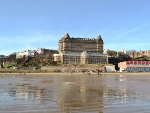 a large building sitting on top of a beach at Beach Walk Cottage in Scarborough