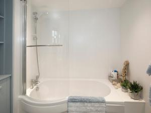 a white bath tub with a glass shower stall in a bathroom at Rose And Crown Yard in Whitby