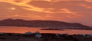 a sunset over a city and a body of water at Margarita Studios in Parikia