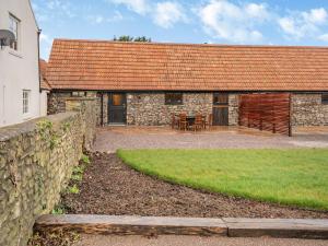 a stone house with a table and chairs in front of it at Pippin-uk41837 in Clevedon