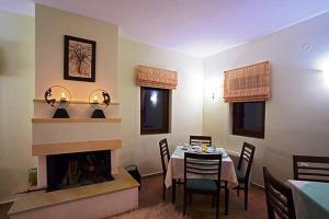a dining room with a table and a fireplace at Guesthouse Michobeis in Kamarína