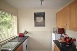 a small kitchen with a sink and a refrigerator at Boswell-Large Balcony Apartment-Town & Racecourse in Doncaster