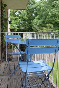 two blue chairs sitting on a porch at Boswell-Large Balcony Apartment-Town & Racecourse in Doncaster