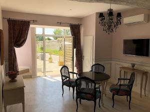 a dining room with a table and chairs and a television at Cottage du chateau for 4 people 90 M- 2 bedrooms 2 bathrooms pool in Azay-le-Rideau