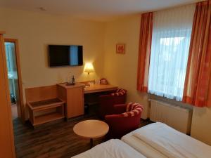 a hotel room with a bed and a desk at Landgasthof Niebler in Adelsdorf