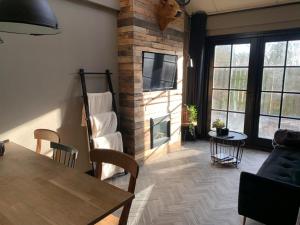 a living room with a table and a fireplace at Sleepzzz in Heusden