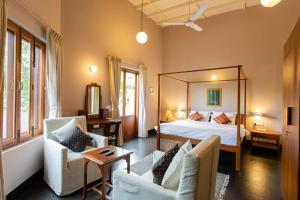um quarto de hotel com uma cama e duas cadeiras em Fully AC 3BDHK villa with Jacuzzi pool and courtyard em Porvorim