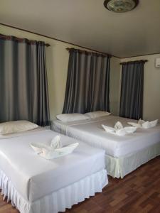 two white beds in a room with curtains at Mook Paradise Bungalow in Koh Mook