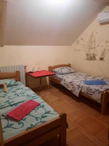 Cette chambre comprend 2 lits et une table. dans l'établissement LUG, à Belgrade