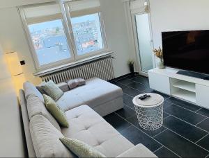 ein Wohnzimmer mit einem Sofa und einem Flachbild-TV in der Unterkunft Esch/Alzette city apartment in Esch-sur-Alzette