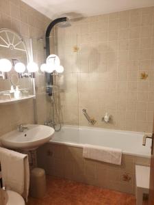 La salle de bains est pourvue d'un lavabo et d'une baignoire. dans l'établissement Apartment Rathausplatz - HOTEL FÜRSTENHOF, à Kempten