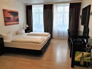 a bedroom with a bed and a piano and windows at Apartment Rathausplatz - HOTEL FÜRSTENHOF in Kempten