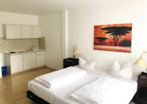 um quarto com uma cama branca e um quadro na parede em Apartment Rathausplatz - HOTEL FÜRSTENHOF em Kempten