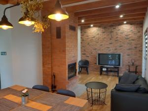 - un salon avec une cheminée en briques et une table dans l'établissement Siedlisko na Winnicy, à Opatów