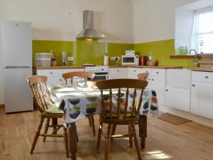 cocina con mesa y sillas en Ysgubor, en Tregarth
