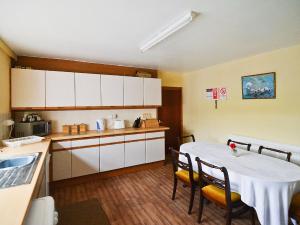 a kitchen with a table and chairs and a kitchen with white cabinets at Kilpatrick Farm House in Pinmore