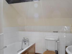 a bathroom with a tub and a toilet and a sink at The Coach House in Corney