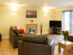 a living room with two couches and a television at Owls Park in Saint Endellion