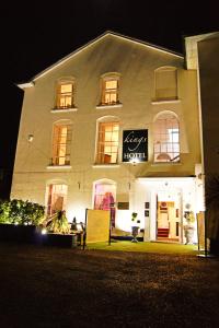 a white building with a sign on it at night at Kings Hotel in Newmarket