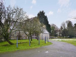 a stone building with blue poles in front of a road at The Carriage House in Belsay