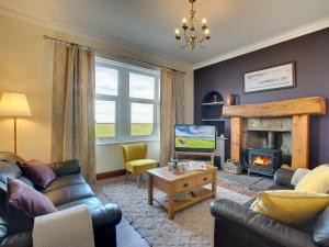 a living room with a couch and a fireplace at Heron House in Tweedmouth