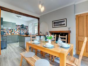 uma cozinha e sala de jantar com uma mesa de madeira e cadeiras em Heron House em Tweedmouth