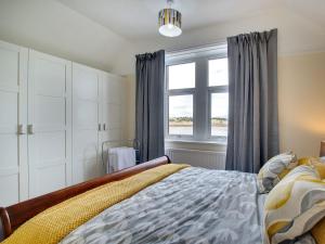 a bedroom with a bed and a window at Heron House in Tweedmouth