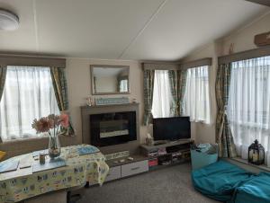 a living room with a fireplace and a tv at Beachhome in Heacham
