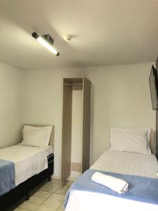 - 2 lits dans une chambre avec des draps blancs dans l'établissement HOTEL RIO VERDE, à Rio Verde