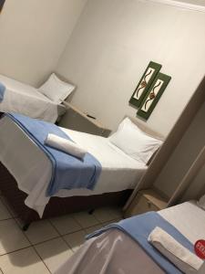 two twin beds in a small room with at HOTEL RIO VERDE in Rio Verde