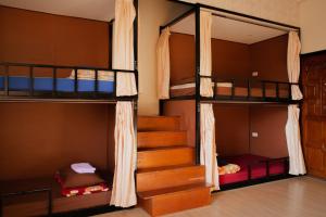 a room with three bunk beds and a staircase at Grace hostel - Chiang Rai in Chiang Rai